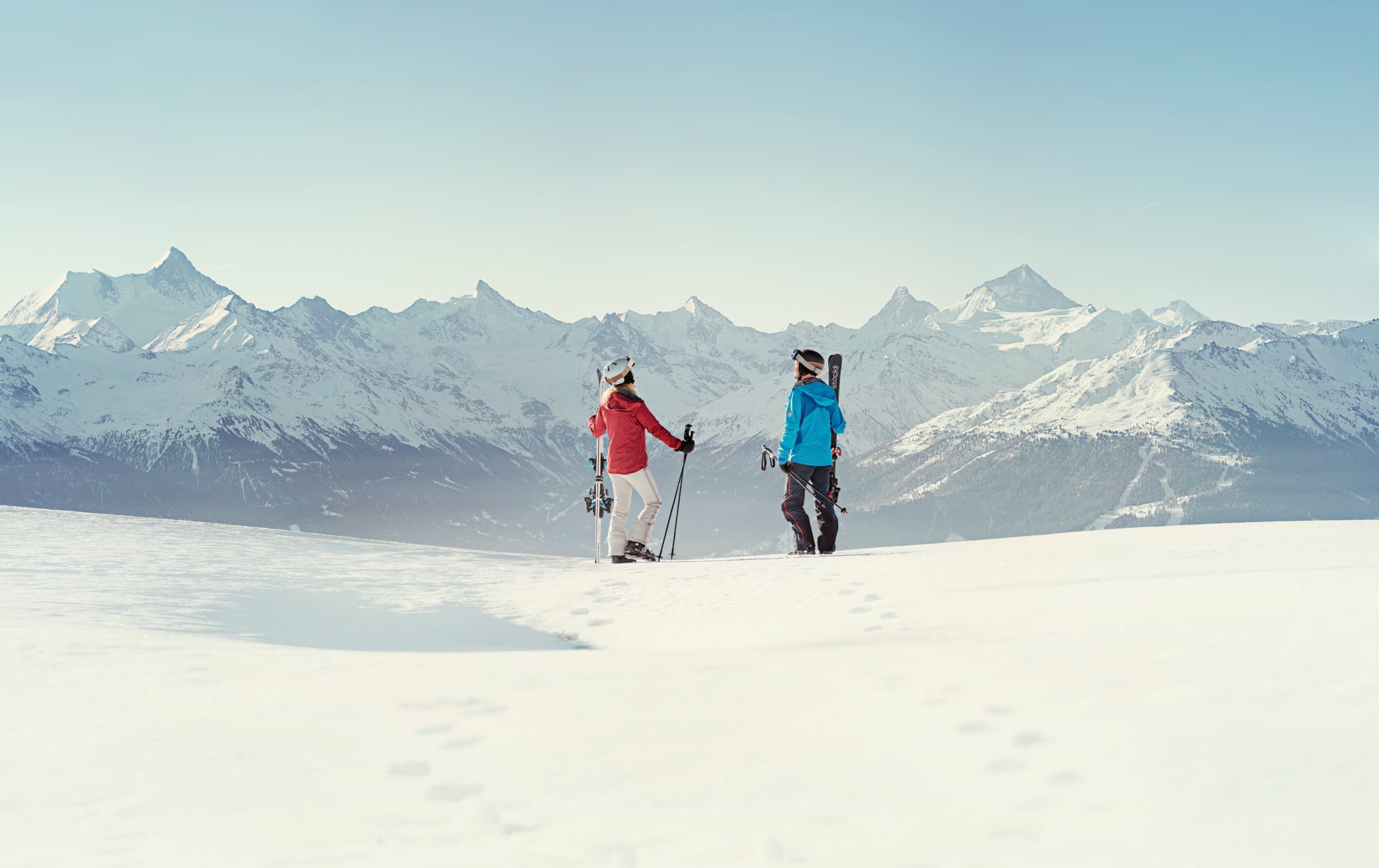 Couple taking break from skiing to admire view of Crans Montana ski resort